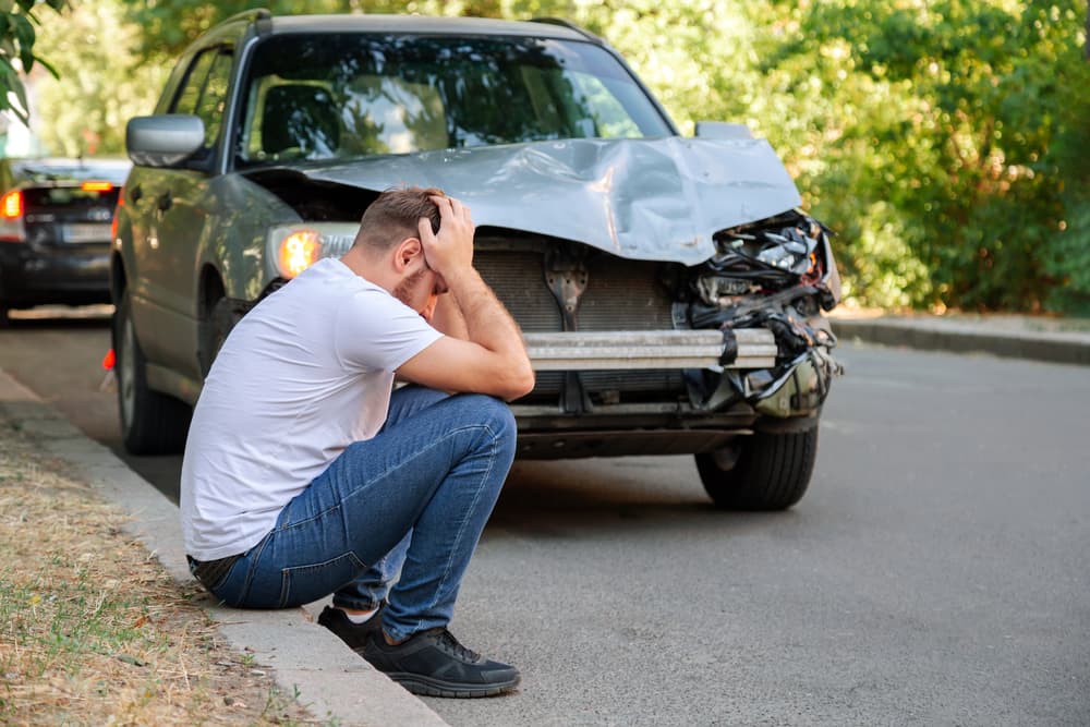 Man sitting on floor and holding his head after a car accident in Bronx NY. 