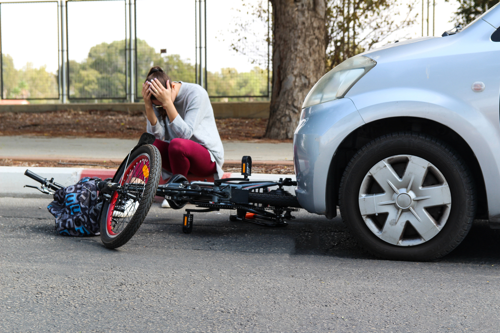 A man shocked and sitting on the floor after a car hit his biker in Manhattan