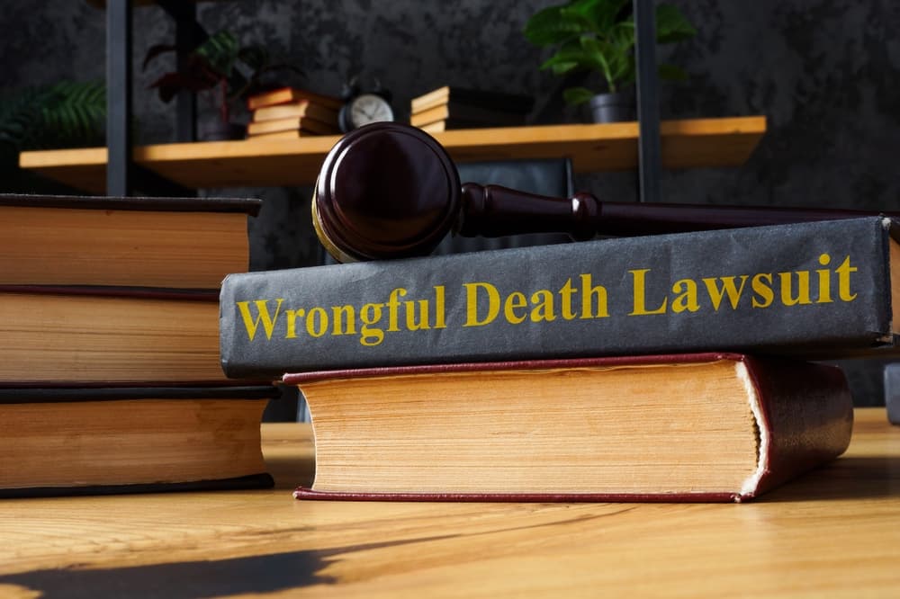 Pile of law books with a focus on a document titled 'Wrongful Death Lawsuit,' symbolizing legal resources related to wrongful death claims.